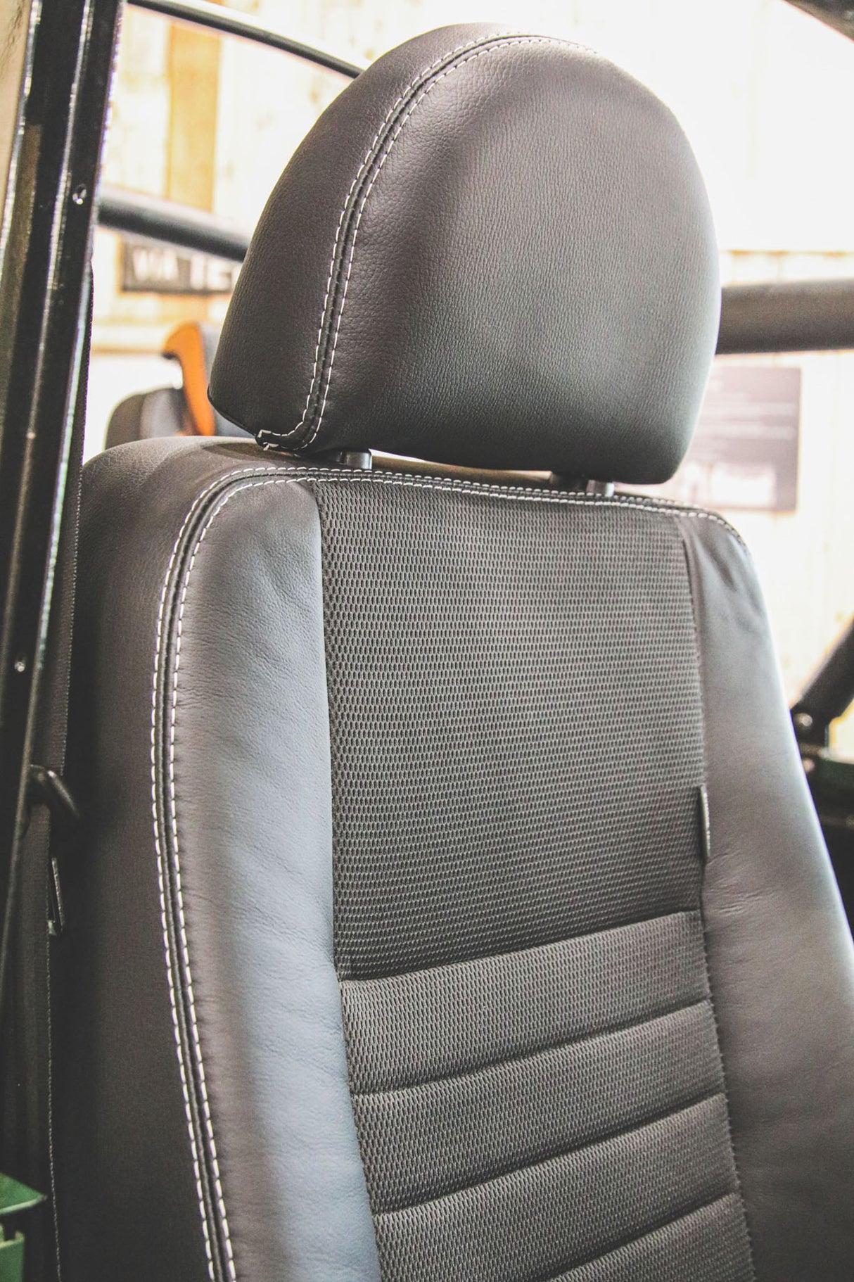 Defender "Puma" Frontsitz links (schwarzer Stoff, schwarzes Leder) beheizt